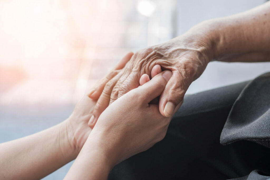 Woman Holding Old Lady's Hand