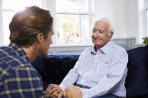 Adult son talking to his senior father.