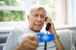 Older man taking on the phone being scammed.