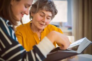 Older woman and her daughter reading a book